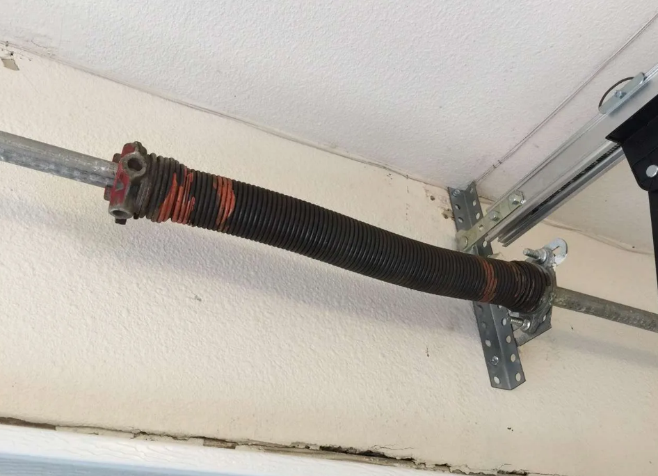 a skilled technician from Parkland Garage Door Repair Services carefully replacing a garage door spring, demonstrating expertise in garage door maintenance and repair. The technician is wearing a uniform, ensuring high-quality service delivery for Parkland, FL residents.