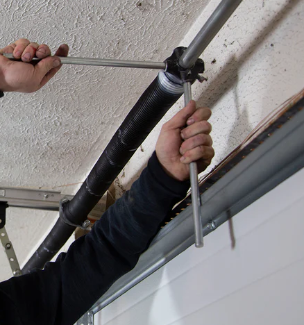 A technician repairing a garage door spring in Parkland, FL, showcasing professional garage door repair services.