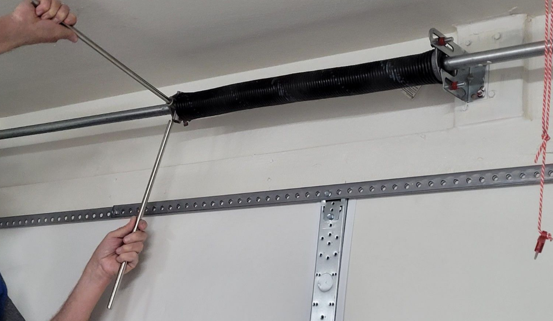 Close-up of a technician repairing a garage door spring, showcasing expert garage door repair services in Parkland, FL.